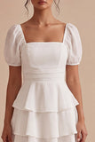 Um vestido mini branco de decote quadrado com folhos e mangas bufantes de linha branca