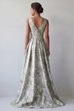 Uma linha de vestido floral verde-claro longo e franzido de mãe da noiva com bolsos