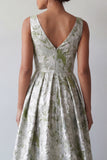 Uma linha de vestido floral verde-claro longo e franzido de mãe da noiva com bolsos