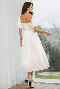 Um vestidinho branco plissado com mangas puff