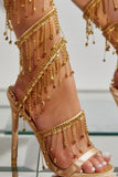 Sandálias douradas de salto alto cintilantes com borla