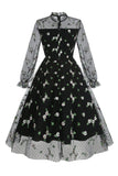 Um vestido vintage preto de pescoço alto de linha com renda