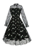 Um vestido vintage preto de pescoço alto de linha com renda